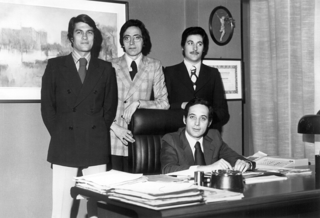 Alla scrivania Paolo Capogrossi con i due fratelli Massimo (in piedi a destra) e Fabio (in piedi al centro) ed un collaboratore